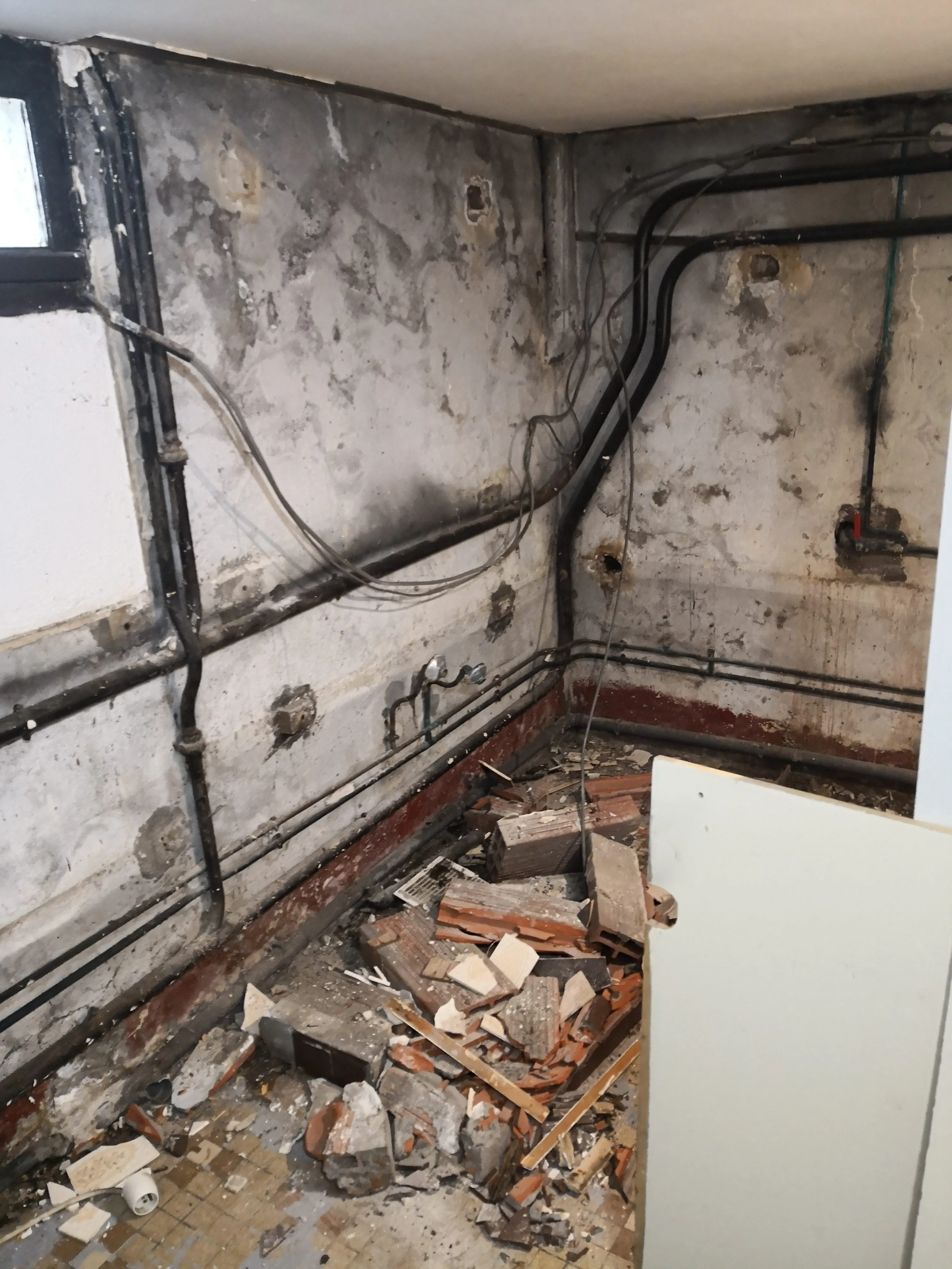 Salle de bain très dégradée mise à nu avant travaux