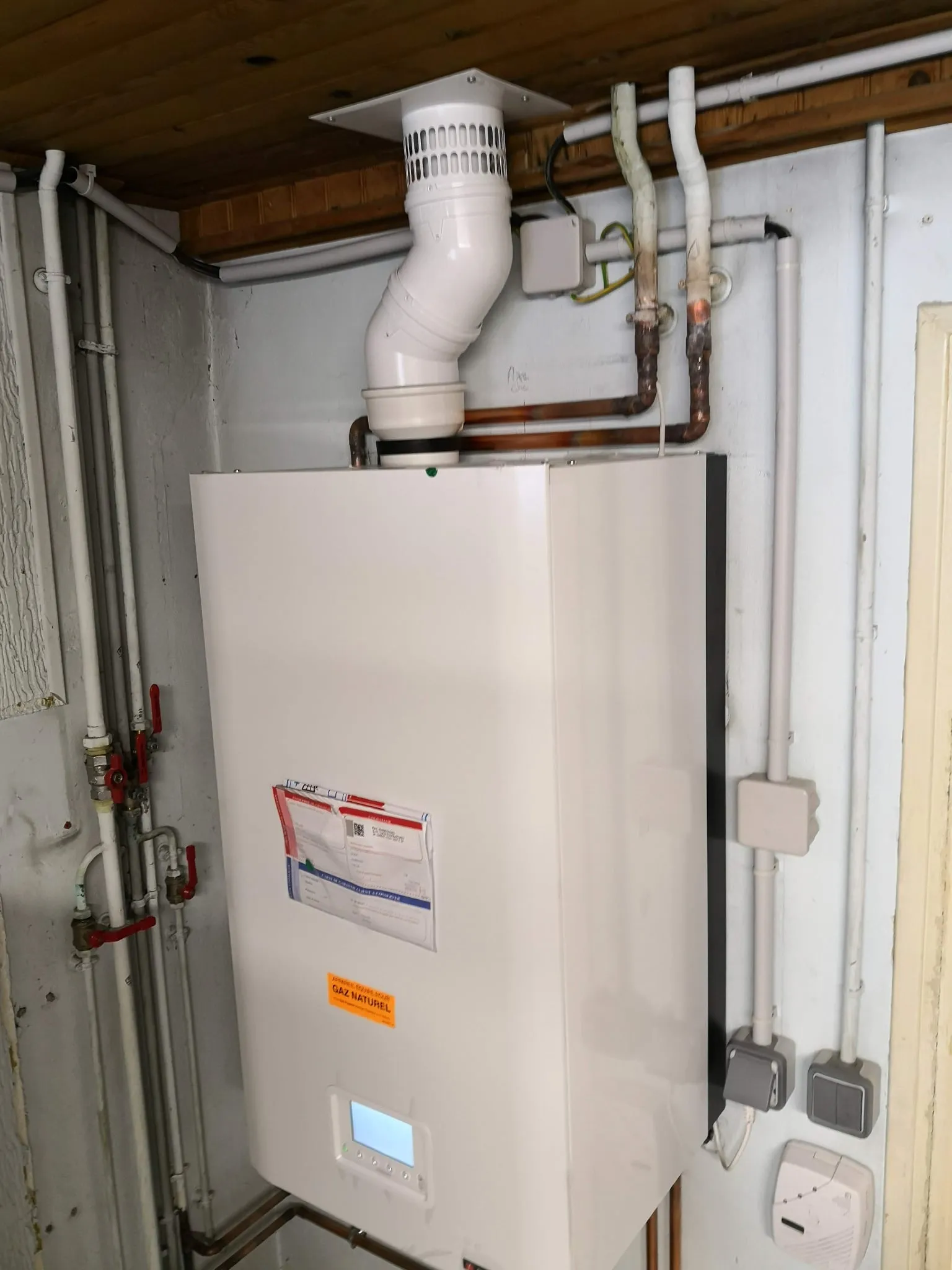Chaudière gaz à condensation neuve installée avec son conduit de fumée