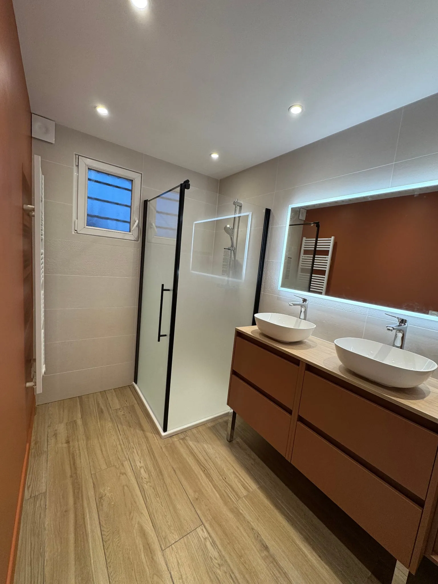 Salle de bain terminée : double vasque, miroir rétroéclairé et douche à l'italienne