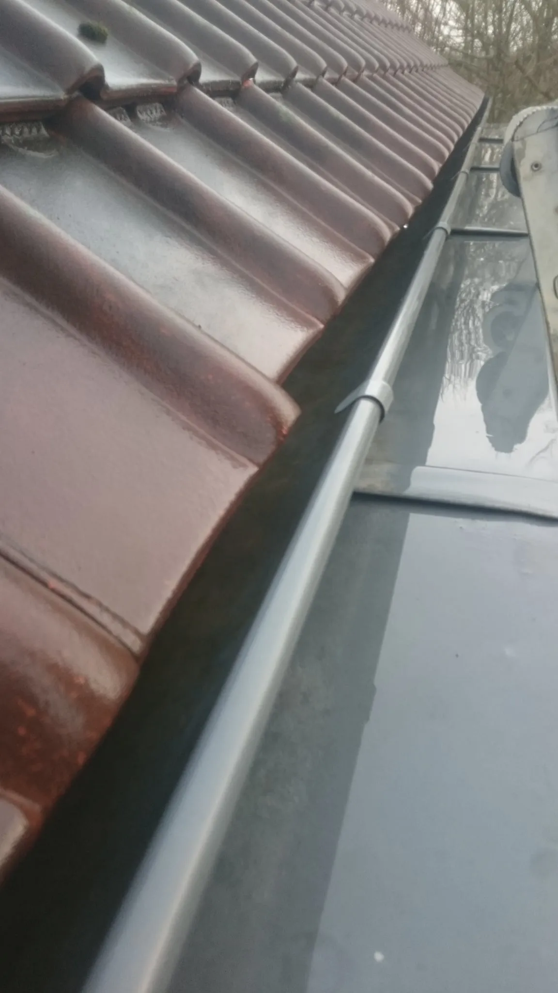 Raccord de zinguerie et gouttière en zinc le long de la couverture en tuile