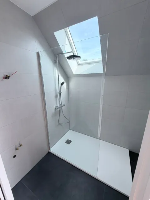 Première salle de bain carrelée sous fenêtre de toit